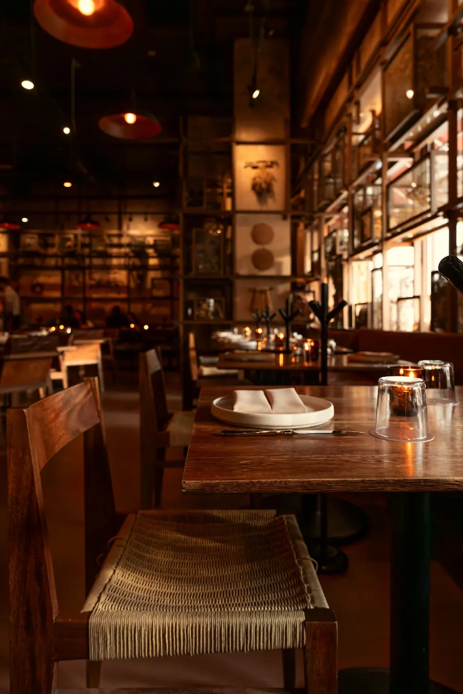 Comedor interior con mesas de madera y luz cálida