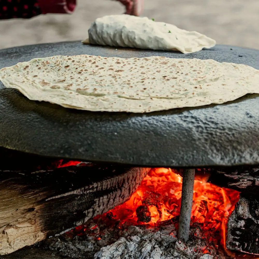 Tortilla grande sobre un comal encima de la leña